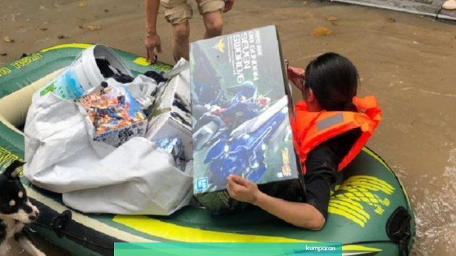 Wanita Ini Rela Menerjang Banjir Demi Selamatkan Gundam Suaminya