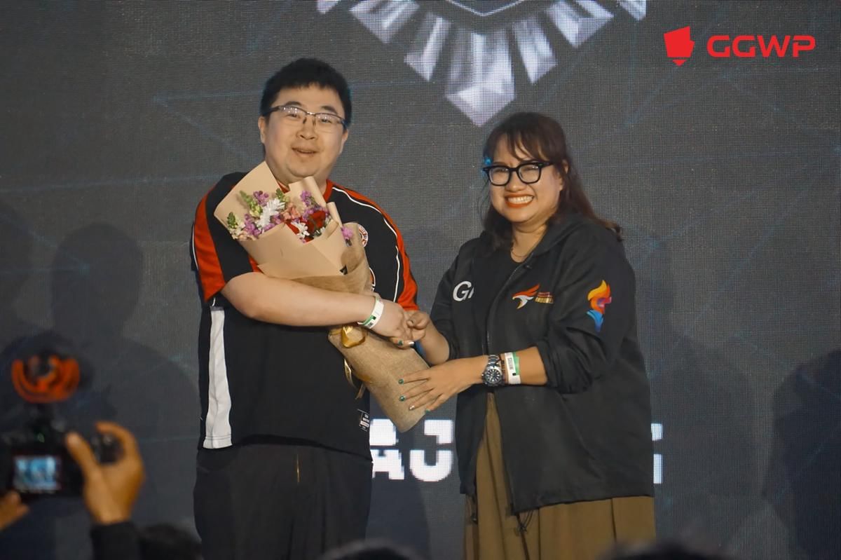 Glorya Famiela Ralahallo, Wakil Ketua Bidang Kompetisi PB ESI, menyerahkan karangan bunga untuk CEO Bigetron by Vitality, Edwin Chia. (Dok. GGWP)