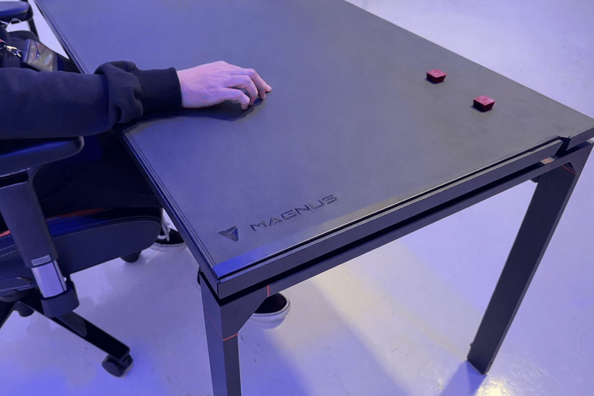 Focused hand on a Magnus desk.png