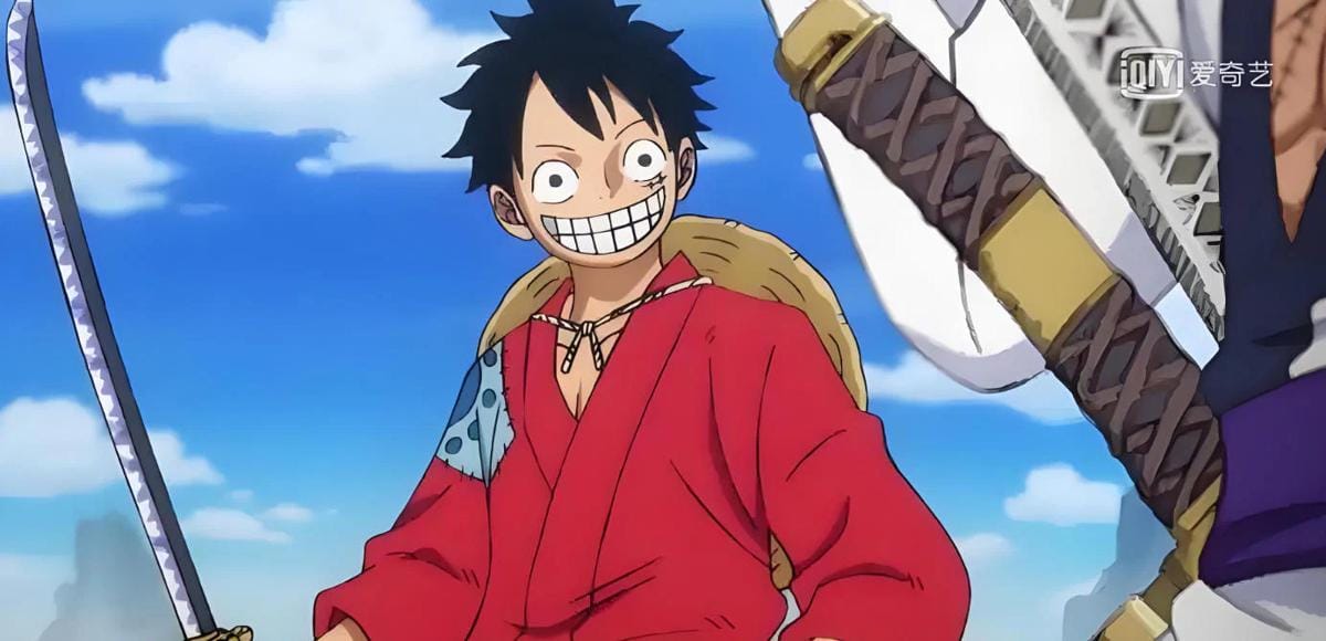 Karakter anime mengenakan kimono merah tersenyum lebar sambil memegang pedang di bawah langit biru dengan awan putih.