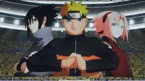 Koreo raksasa menampilkan karakter anime Naruto, Sasuke, dan Sakura di tengah stadion dengan penonton memenuhi tribun.